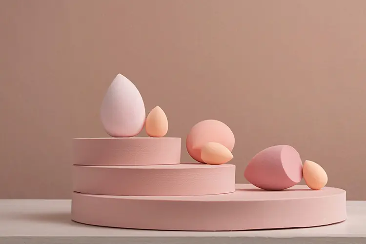 Applying luminous foundation with a damp beauty sponge for a dewy skin finish